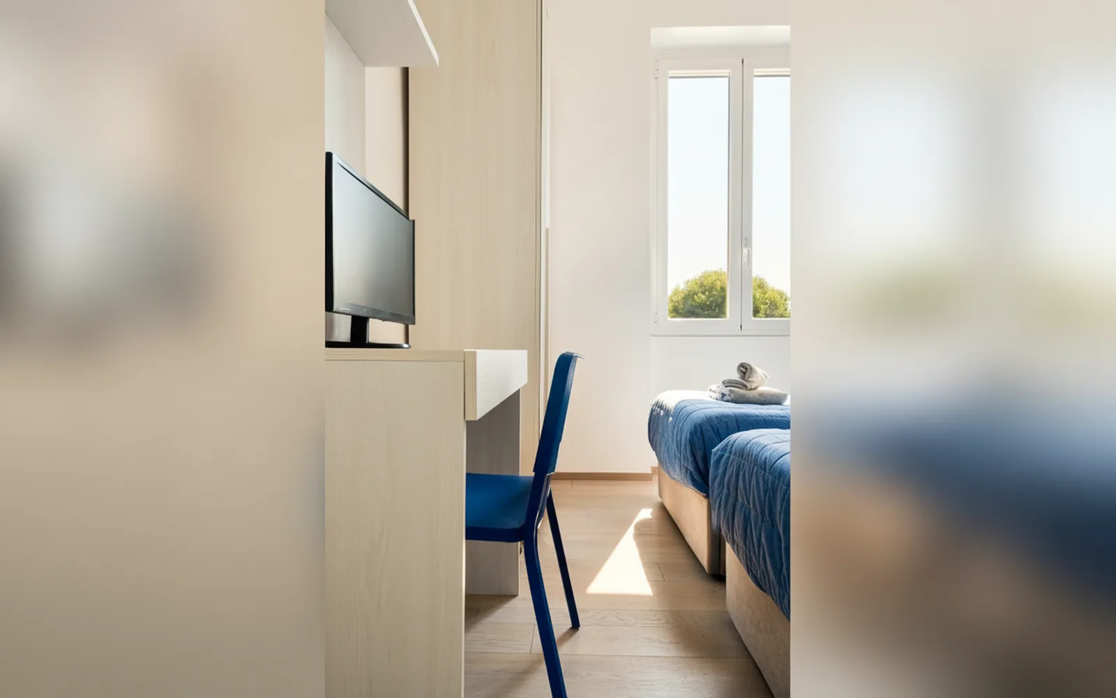 Camera doppia con scrivania, sedia e TV