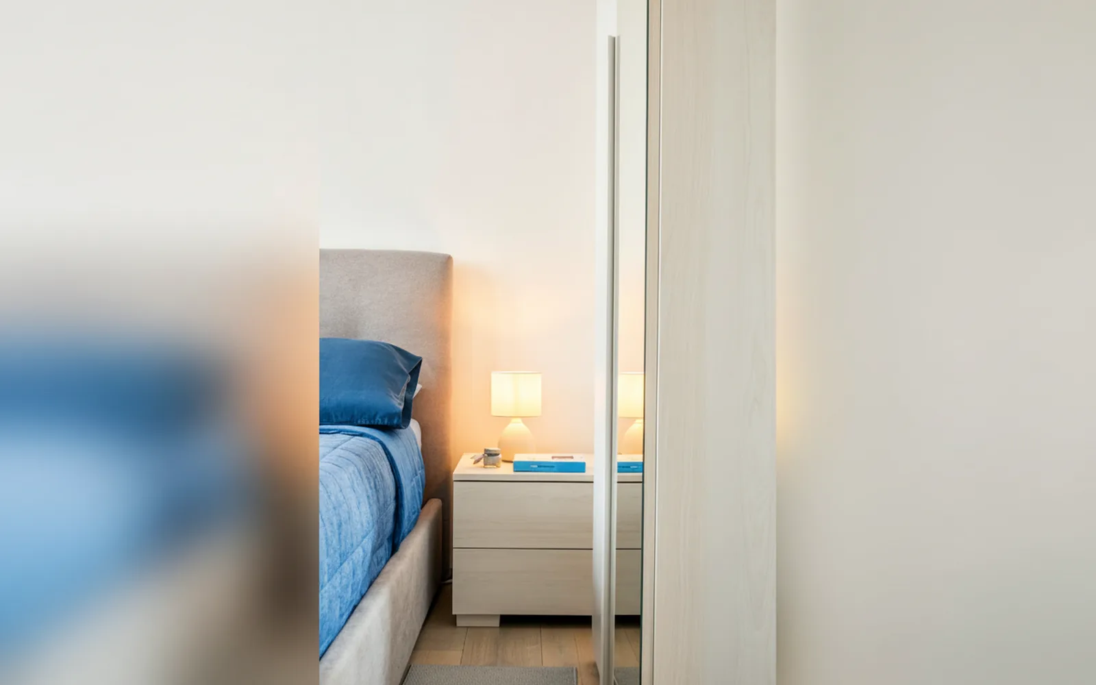 Letto e comodino con lampada in una camera doppia